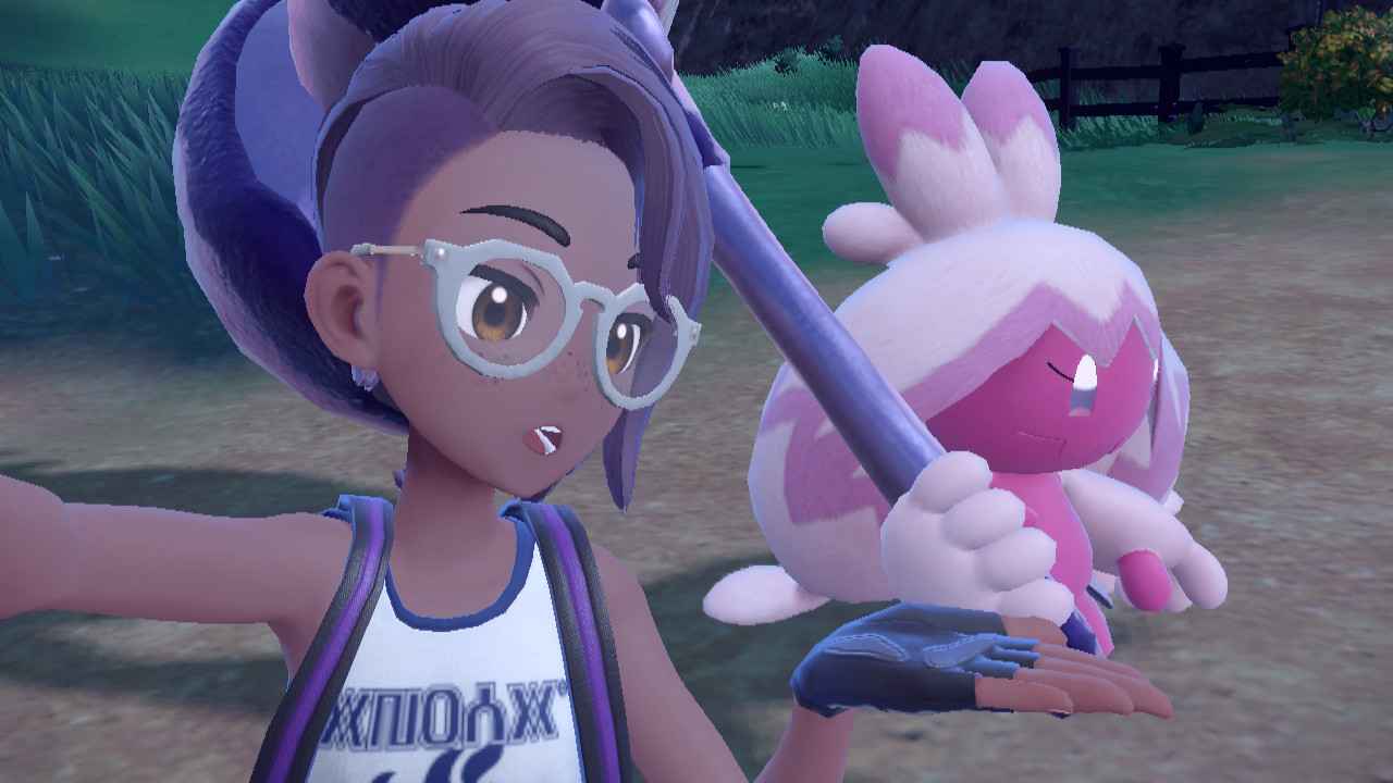 A purple-haired pokemon trainer with glasses presents her Tinkaton, a cheerful-looking pink creature with a giant metal hammer in Pokemon Scarlet and Violet
