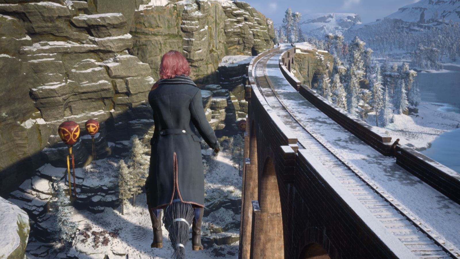 Wizard with pink hair on a broom flying over Hogsmeade station in Hogwarts Legacy.