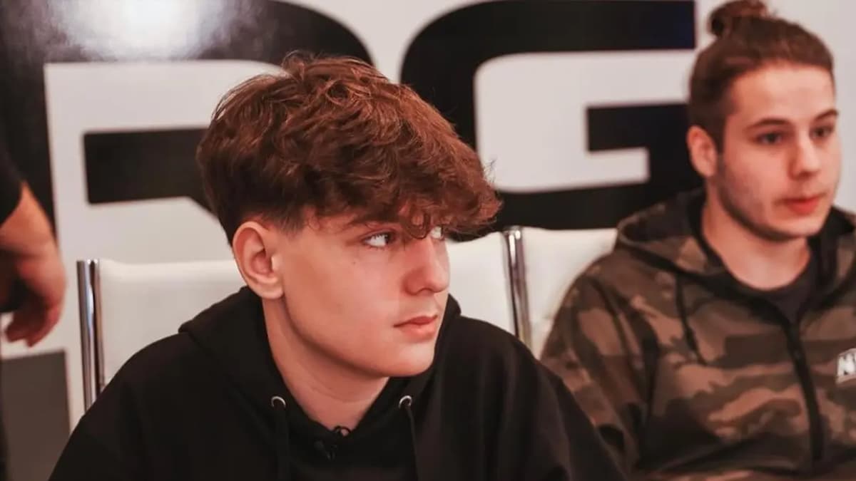 Clix with his head turned sitting next to another ma