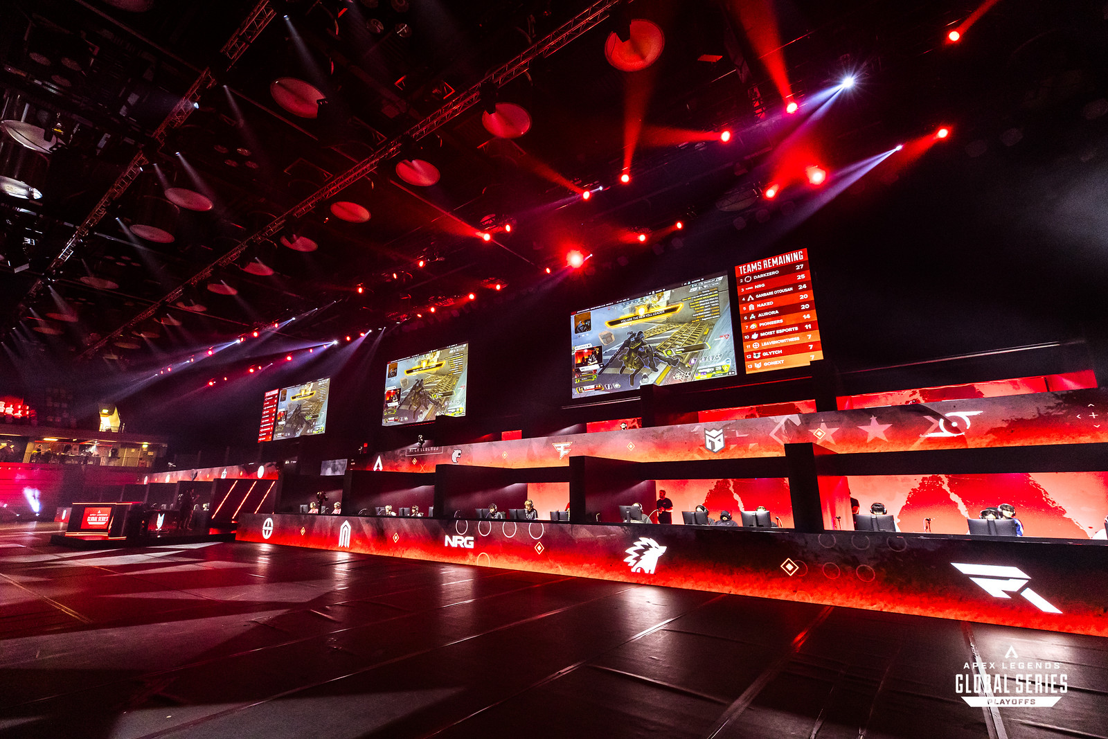 The ALGS Split 2 Playoffs stage, with several teams in their areas and esports logos on red screens in front of them.