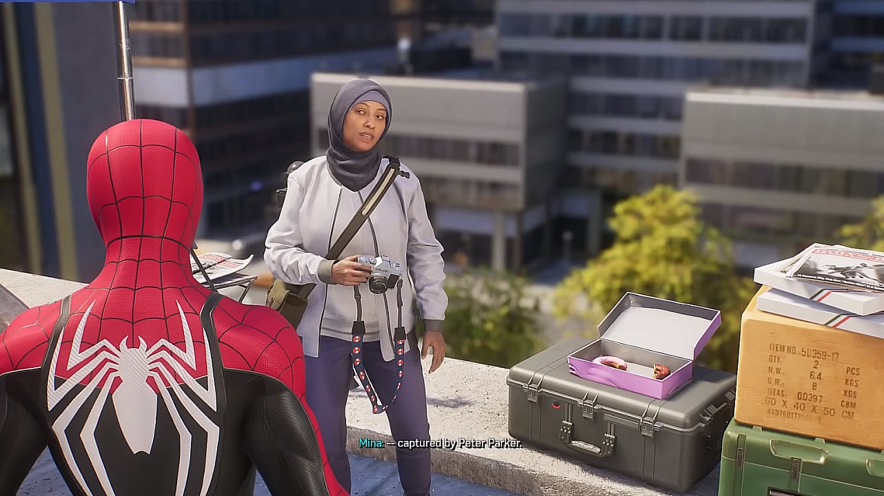 There is a shot of Spider-Man talking with a photographer on a rooftop. She has an open box of donuts nearby.