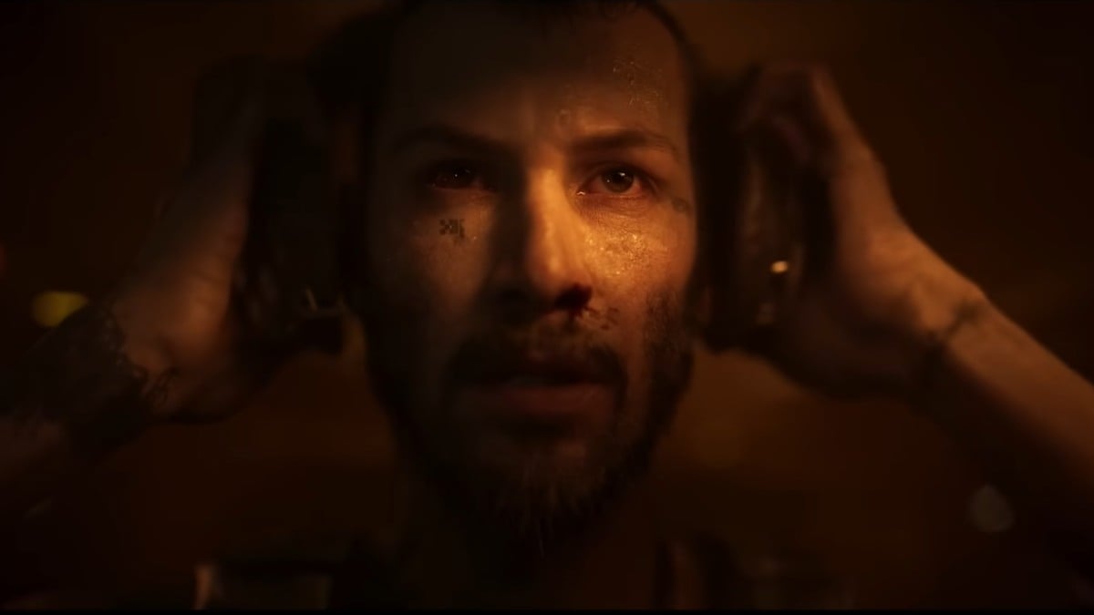 Close up shot of Armored Core protagonist placing headphones on his ears while looking determined