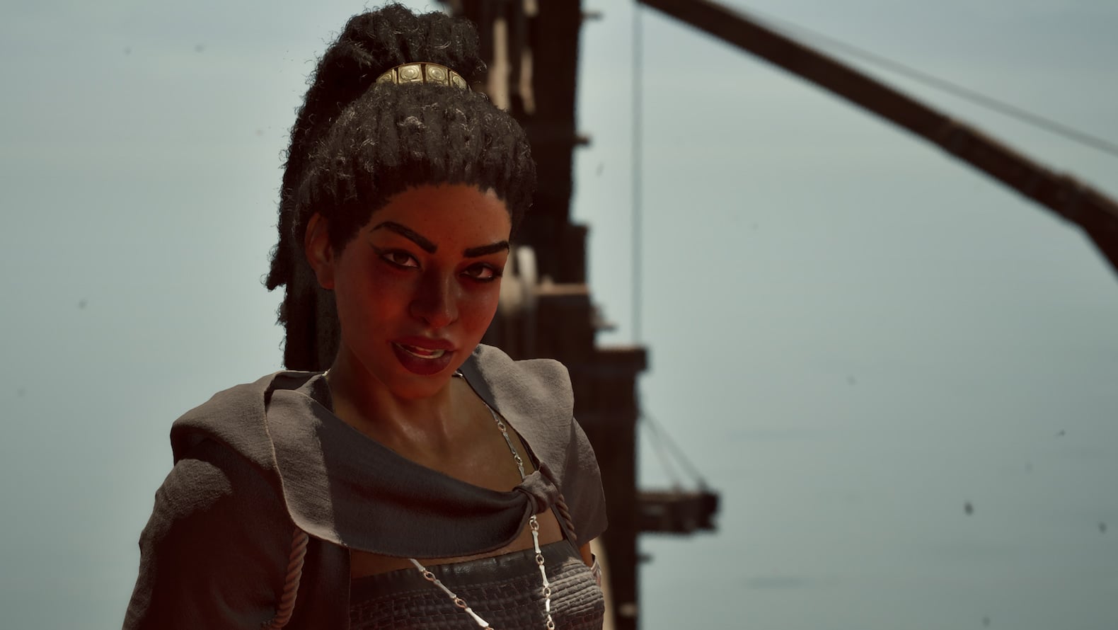 Giatta, a woman with dark braided hair pulled into a ponytail, wears dark clothing and looks