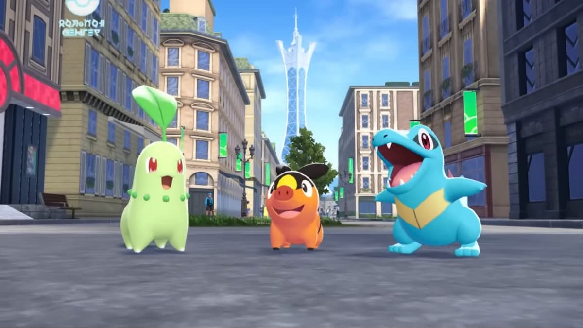 a trio of Pokémon on a city street: Chikorita to the left, Tepig on center, Totodile to the right