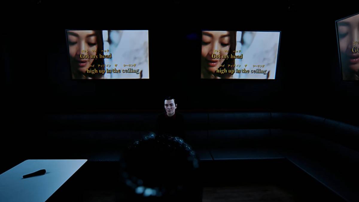 Standing in front of Hideki singing karaoke with the lyrics on multiple screens ahead of Naomi