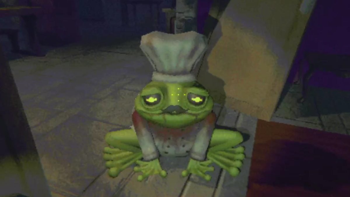 A full body shot of the moustache-wearing frog with a chef's hat on top of his head