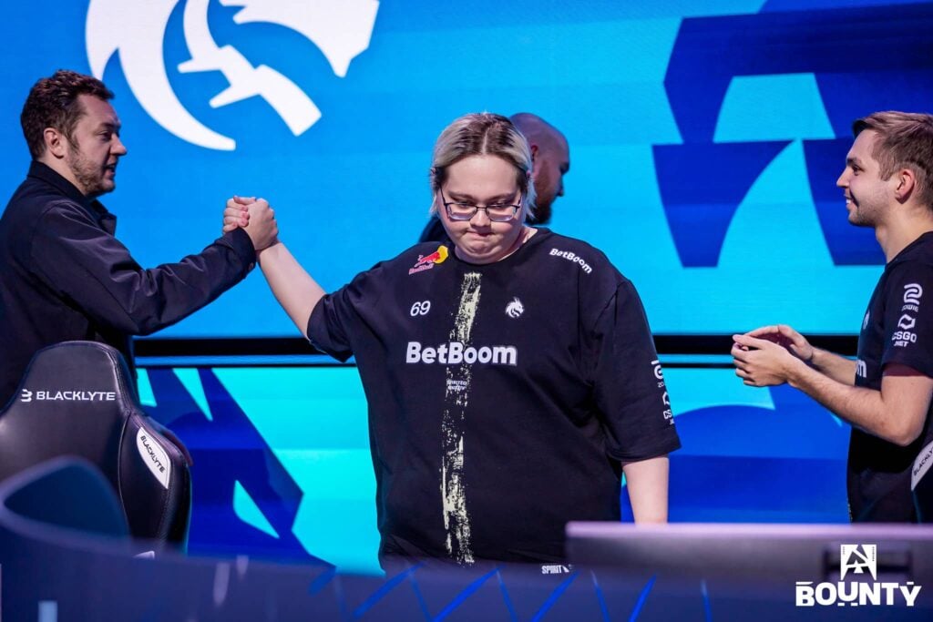 Team Spirit's magixx looks down while shaking hands with a team staff after a match in a BLAST Bounty tournament.