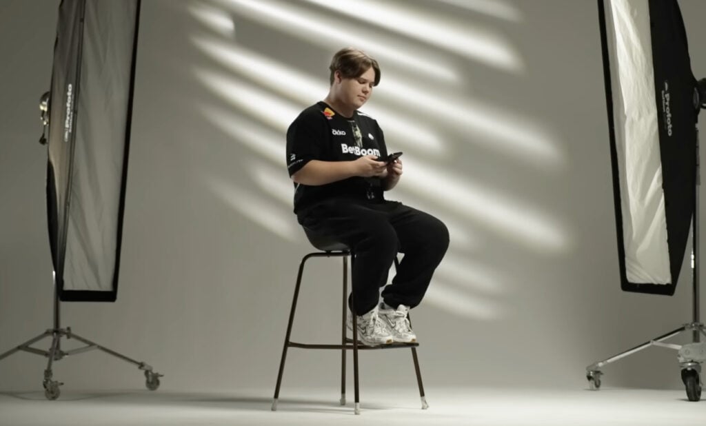 zweih sitting on a high chair while looking at his phone in Team Spirit's video announcing his inclusion to the roster.