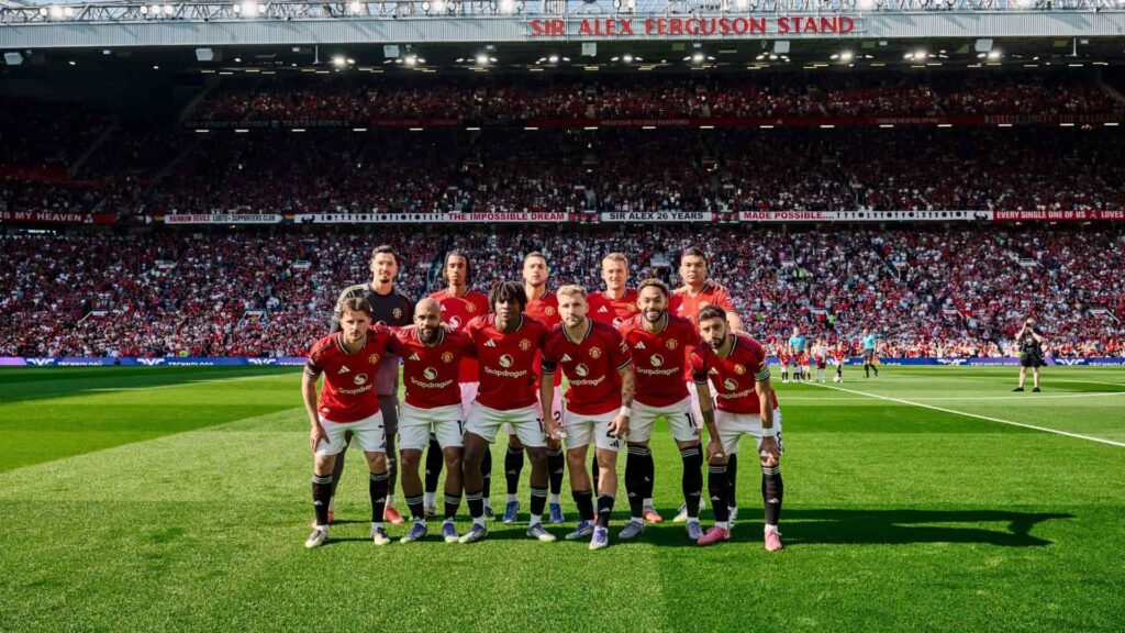 Macnhested United players take a photo with the crowd at Old Trafford in the background before their first match in the Premier League 2025-26 season.