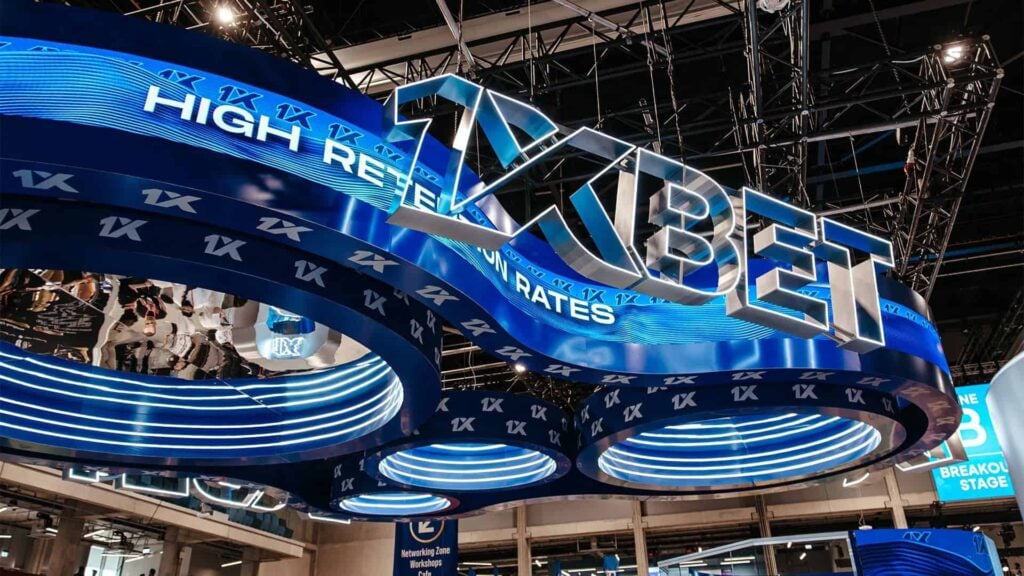 1xBet brand name prominently displayed in a booth during an event