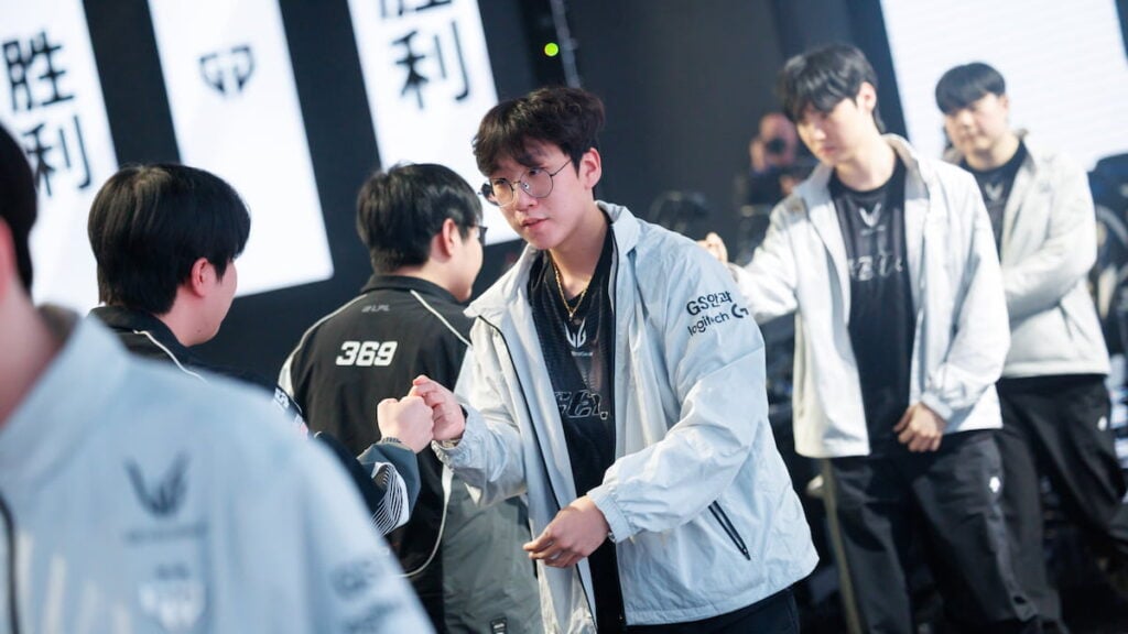 Top Esports and Gen.G Esports fist bump onstage at League of Legends Worlds 2025 Swiss Stage on October 23, 2025 in Beijing, China.