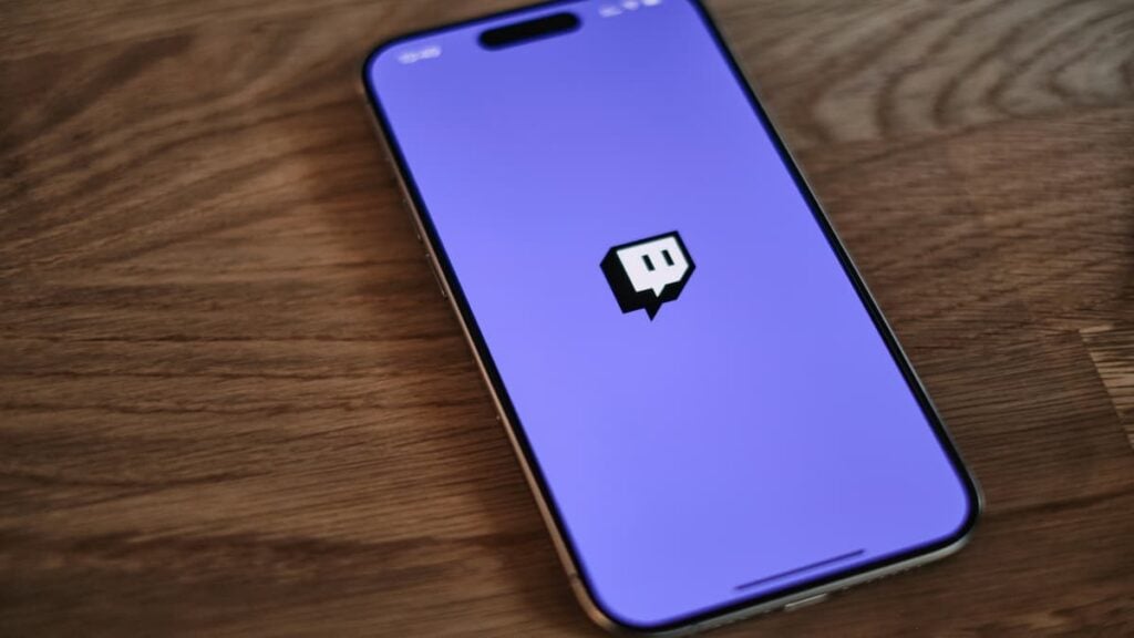 Picture of a smartphone with the Twitch app opened, lying on a desk.